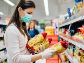 mulher-no-supermercado-observando-embalagem-de-macarrao-royalty-free-image